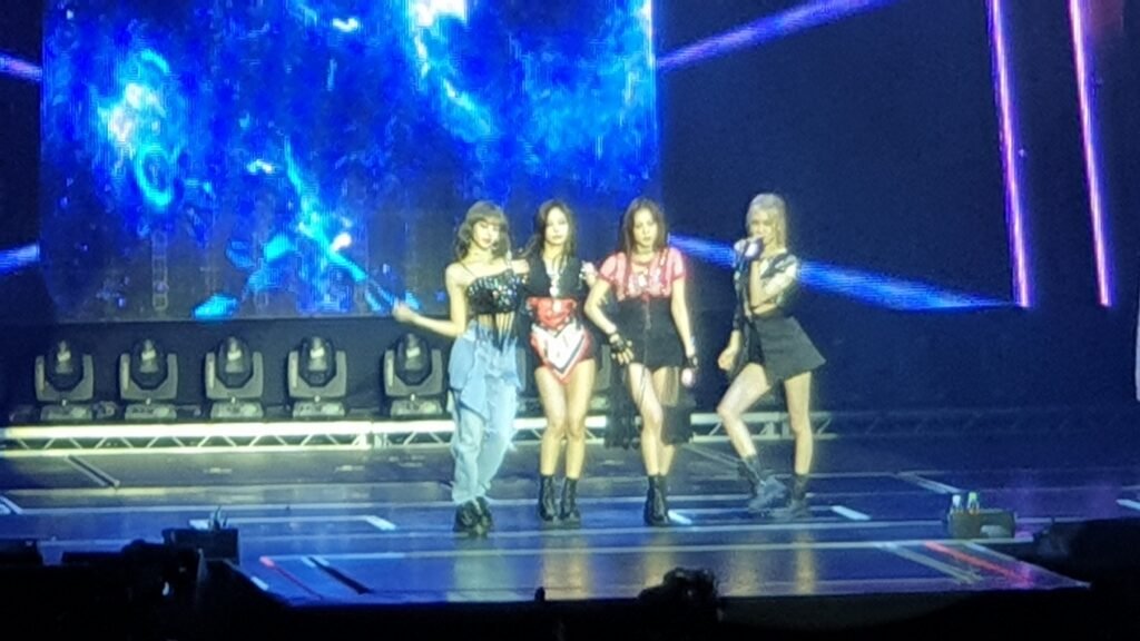 BLACKPINK members including Lisa and Jisoo performing at an Amsterdam concert