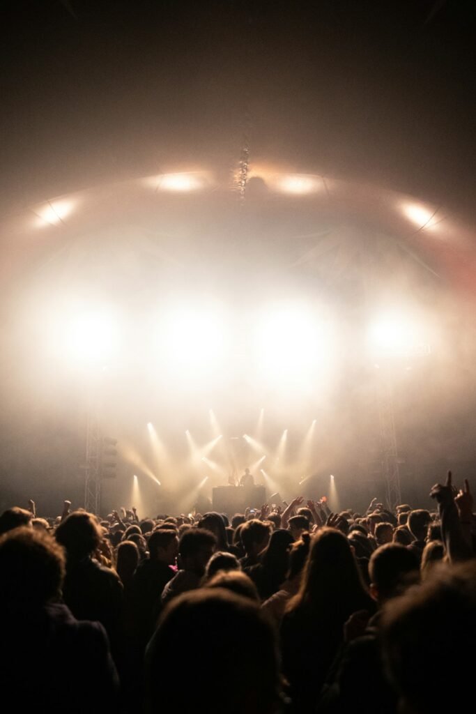 Concert crowd cheering near a stage, illustrating K-pop fan chants