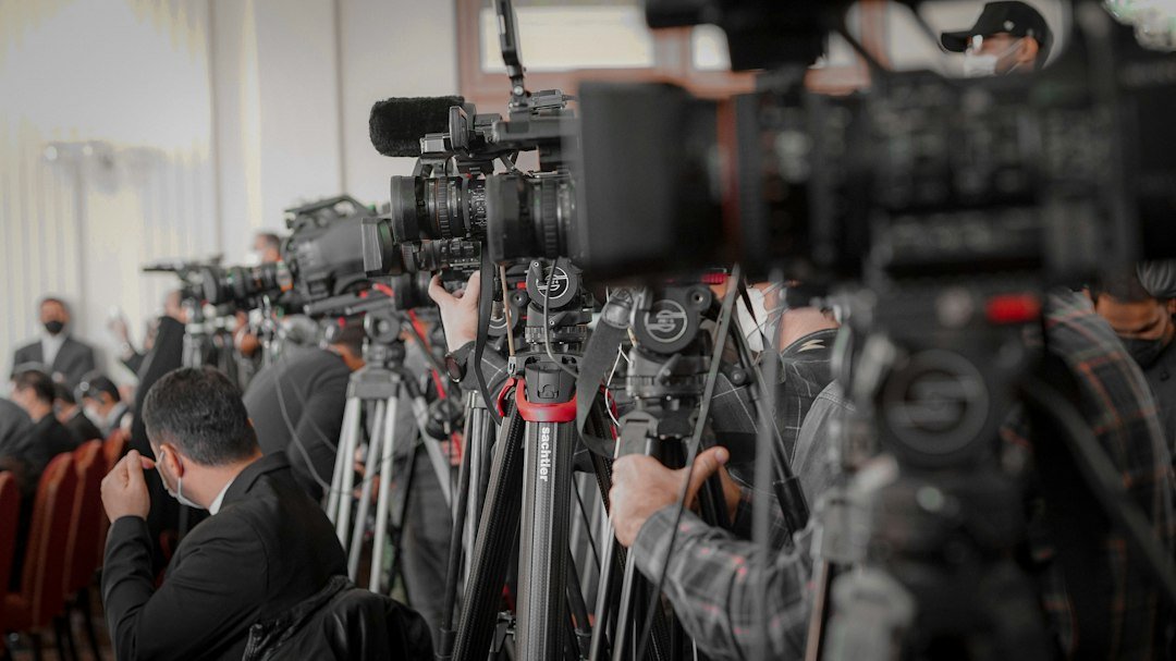 Media cameras and reporters at an event, illustrating how K-pop award stories travel through international news coverage
