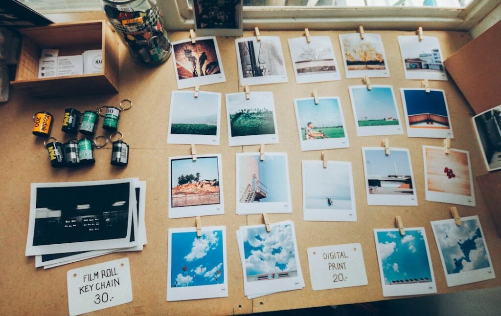 Photo cards and printed photographs arranged on a desk, illustrating K-pop photocard collecting