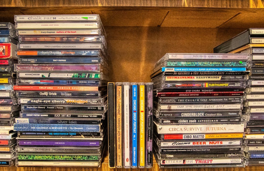 Physical music albums and CD cases on a shelf, illustrating K-pop album formats
