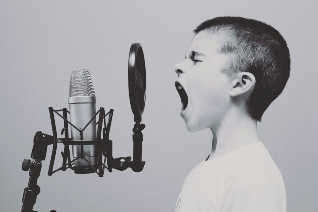 Young singer at a microphone, illustrating BIGHIT MUSIC's 2026 global audition search for new talent
